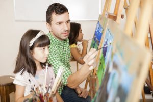Art teacher helping a student