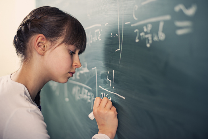 Little girl writing difficult mathematics equations